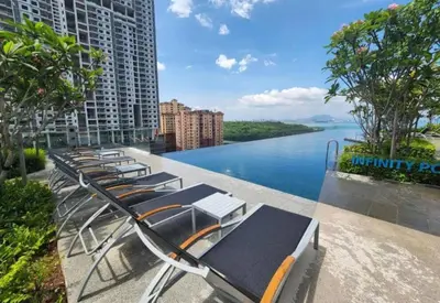a row of chaise lounge chairs on a balcony overlooking a river at Urban Suites, Best Seaview and Cityview in Town in Jelutong
