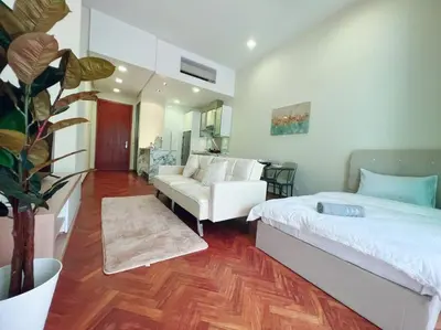 a bedroom with a white bed and a couch at Strait Quay Marina Cozy Suite with Bathtub by Uptrend Home Management in Tanjong Tokong