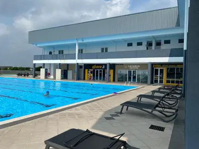 a swimming pool with chairs in front of a building at Rumah Aidin Homestay in Sitiawan