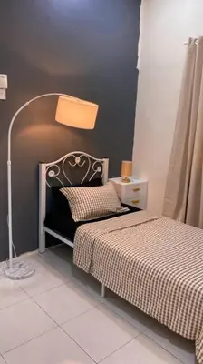 a bedroom with a bed and a lamp next to it at Rumah Aidin Homestay in Sitiawan