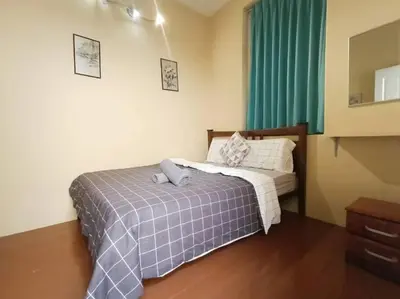 a bedroom with a bed with a plaid blanket at Cheerful 6BR Town House @ Geortown for 5-14pax by Cohans in George Town
