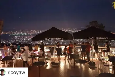 a group of people sitting under umbrellas on a rooftop at Cheerful 6BR Town House @ Geortown for 5-14pax by Cohans in George Town