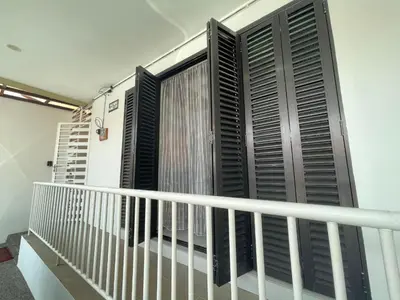 a balcony with black shutters and a curtain at Thetamu Homestay مسلم Kepala Batas in Kepala Batas