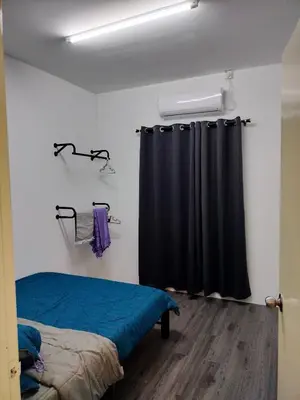 a bedroom with a bed and a black curtain at AZK HOMESTAY in Sungai Besar