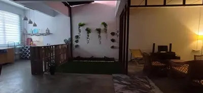 a living room with a door with plants on the wall at Cozy Nature Homestay - Free Wifi Disney Hotstar ADS in Nibung Tebal