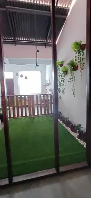 a room with a green lawn in the middle at Cozy Nature Homestay - Free Wifi Disney Hotstar ADS in Nibung Tebal