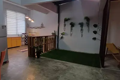 a living room with a green floor in a room at Cozy Nature Homestay - Free Wifi Disney Hotstar ADS in Nibung Tebal