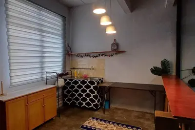 a kitchen with a counter and a table and a window at Cozy Nature Homestay - Free Wifi Disney Hotstar ADS in Nibung Tebal