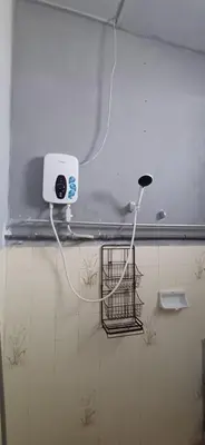 a white light on a wall in a bathroom at Cozy Nature Homestay - Free Wifi Disney Hotstar ADS in Nibung Tebal