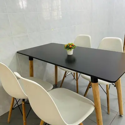 a black table with white chairs and a potted plant at CYC homestay 18 pax in Kampong Batu Lapan