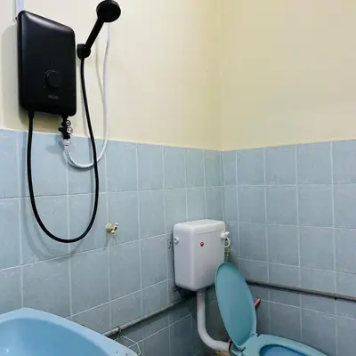 a bathroom with a shower and a toilet with a tank at CYC homestay 18 pax in Kampong Batu Lapan