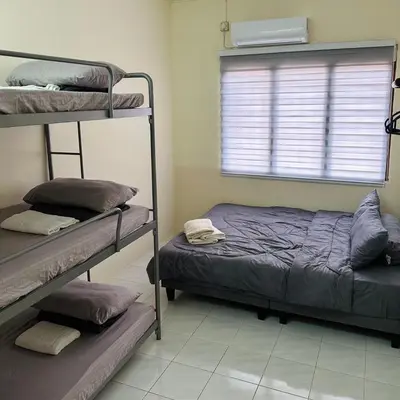 a bedroom with two bunk beds and a window at CYC homestay 18 pax in Kampong Batu Lapan