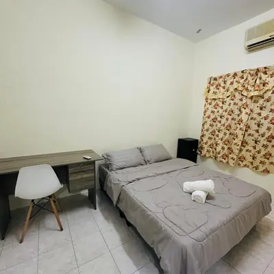 a bedroom with a bed and a desk and a chair at CYC homestay 48 Bercham in Kampong Batu Lapan