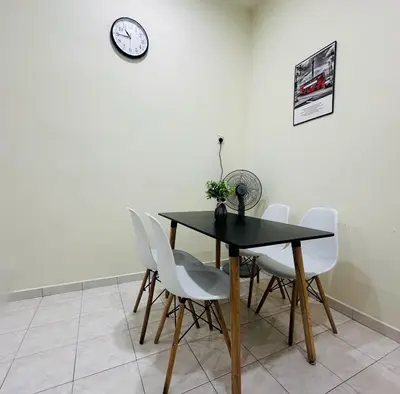 a dining room table with white chairs and a clock on the wall at CYC homestay 48 Bercham in Kampong Batu Lapan