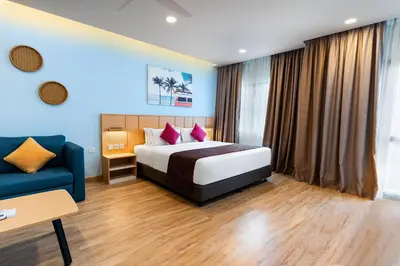 a hotel room with a bed and a blue couch at SGI Vacation Club Villa @ Damai Laut Holiday Resort in Lumut