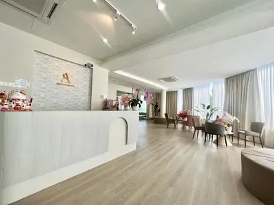 a lobby with a waiting area with tables and chairs at Asimmy Hotel in Kampong Gurun