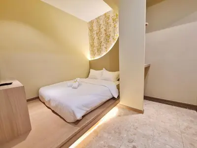 a small bedroom with a bed with white sheets at Asimmy Hotel in Kampong Gurun