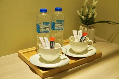 a tray with two cups of toothbrushes and bottles of water at Asimmy Hotel in Kampong Gurun