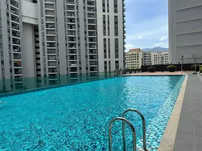 a swimming pool in the middle of two tall buildings at JazzA 2R3B Suite Strait Quay Near Stonyhurst School by Homey Planet in Tanjong Tokong