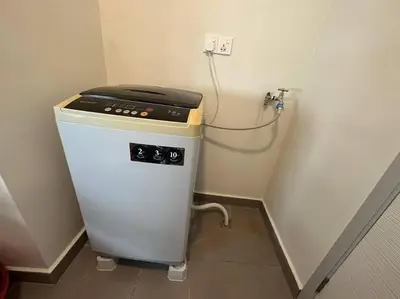 a small refrigerator in a corner of a room at JazzA 2R3B Suite Strait Quay Near Stonyhurst School by Homey Planet in Tanjong Tokong