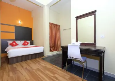 a bedroom with a desk and a bed with a mirror at Hotel Tudor Home Inn Cameron Highlands in Brinchang