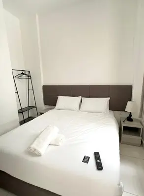 a white bed with two remote controls on it at Lodge 43 House in George Town