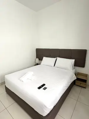a large bed with white sheets and pillows on it at Lodge 43 House in George Town