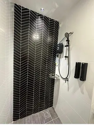 a bathroom with a shower with black tile at BlissFul Homestay_Horizon@IPOH in Ipoh