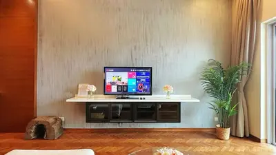 a living room with a flat screen tv on a wall at Straits Quay Highest & Wonderful Seaview Suite in Tanjong Tokong