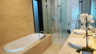 a bathroom with two sinks and a tub and a shower at Straits Quay Highest & Wonderful Seaview Suite in Tanjong Tokong
