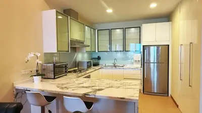a kitchen with a counter with a refrigerator at Straits Quay Highest & Wonderful Seaview Suite in Tanjong Tokong