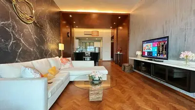 a living room with a white couch and a television at Straits Quay Highest & Wonderful Seaview Suite in Tanjong Tokong