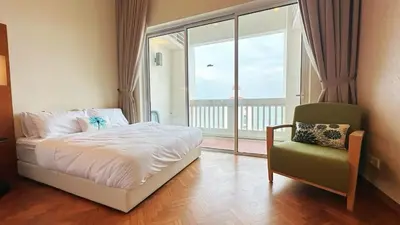 a bedroom with a bed and a chair and a window at Straits Quay Highest & Wonderful Seaview Suite in Tanjong Tokong