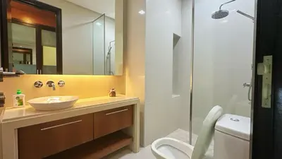 a bathroom with a sink and a toilet and a mirror at Straits Quay Highest & Wonderful Seaview Suite in Tanjong Tokong