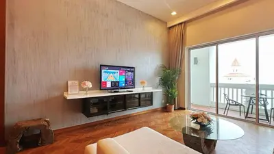 a living room with a flat screen tv on a wall at Straits Quay Highest & Wonderful Seaview Suite in Tanjong Tokong