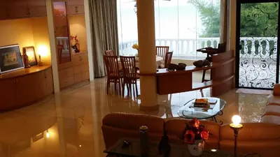 a living room with a couch and a table at Tropical Sea View & Sunshine in Batu Ferringhi