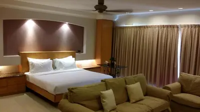 a hotel room with a bed and a couch at Tropical Sea View & Sunshine in Batu Ferringhi