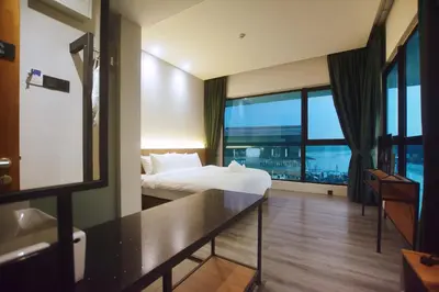 a hotel room with a bed and a large window at Crosview in Kampung Sepetang