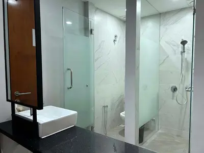 a bathroom with a glass shower and a sink at Crosview in Kampung Sepetang