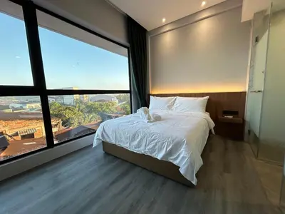 a bedroom with a large bed and a large window at Crosview in Kampung Sepetang
