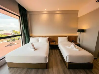 two beds in a room with a large window at Crosview in Kampung Sepetang
