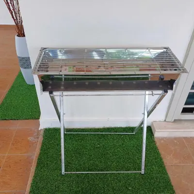 a table with a grill on top of grass at IPOH LYL EVERGREEN HOMESTAY 12pax in Ipoh