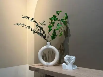 a white vase with a plant in it on a table at Urban Suites Stylish 3BR in Georgetown with Stunning Seaview in Jelutong