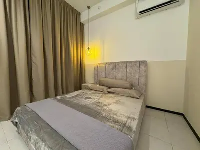 a bedroom with a bed in a room with curtains at Urban Suites Stylish 3BR in Georgetown with Stunning Seaview in Jelutong