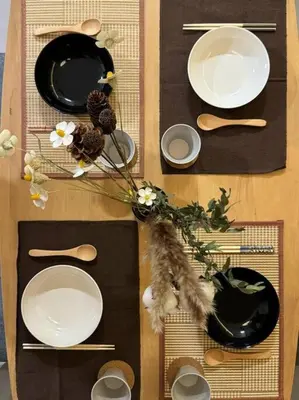 a table with white plates and flowers on it at Urban Suites Stylish 3BR in Georgetown with Stunning Seaview in Jelutong