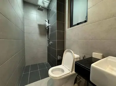 a bathroom with a toilet and a sink and a mirror at Urban Suites Stylish 3BR in Georgetown with Stunning Seaview in Jelutong