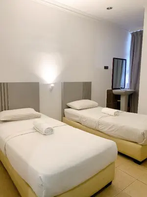a hotel room with two beds and a flat screen tv at One Stop Hotel Ipoh in Ipoh