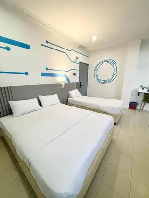 two beds in a room with blue drawings on the wall at One Stop Hotel Ipoh in Ipoh