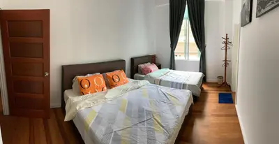 a bedroom with two beds and a window at HappyHomestay in Brinchang