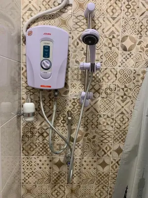 a shower in a bathroom with a soap dispenser at HappyHomestay in Brinchang